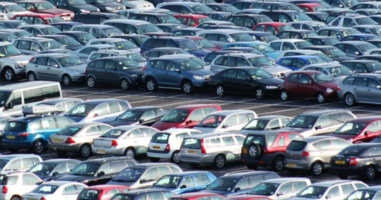 Duży parking pełen samochodów różnych marek i modeli. Szukasz bezawaryjnych samochodów do 20 tys.? Znajdziesz tu wiele opcji.