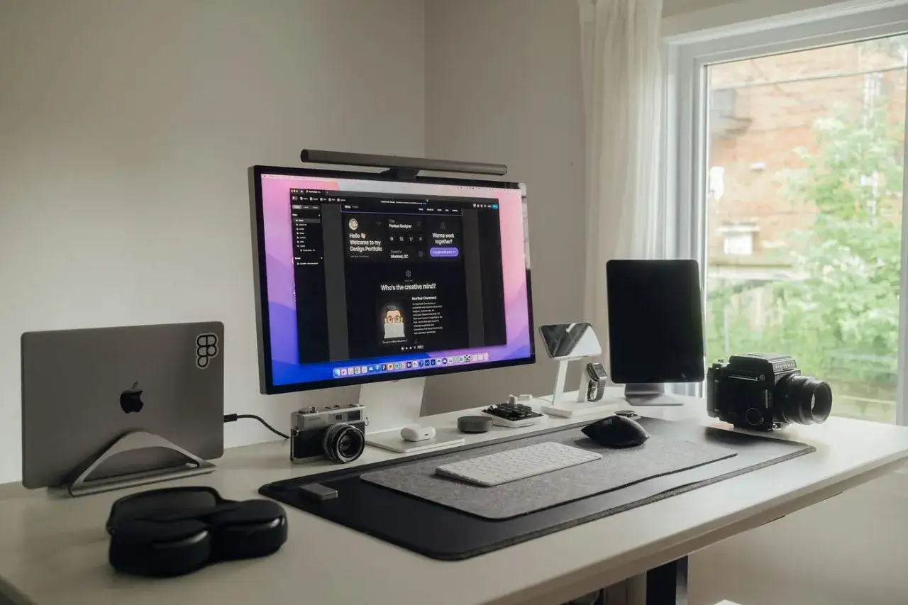 Bureau Mac avec &eacute;cran, MacBook, appareils photo vintage et casque. Id&eacute;al pour un d&eacute;veloppeur qui utilise brew install mac.