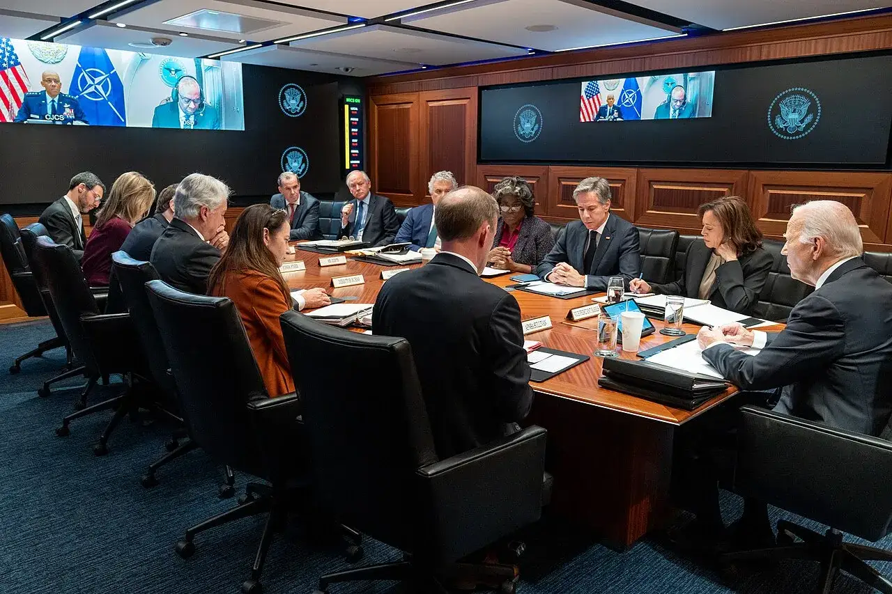 President Biden and advisors in a meeting. This scene implies discussions requiring security clearances for members of Congress and officials.