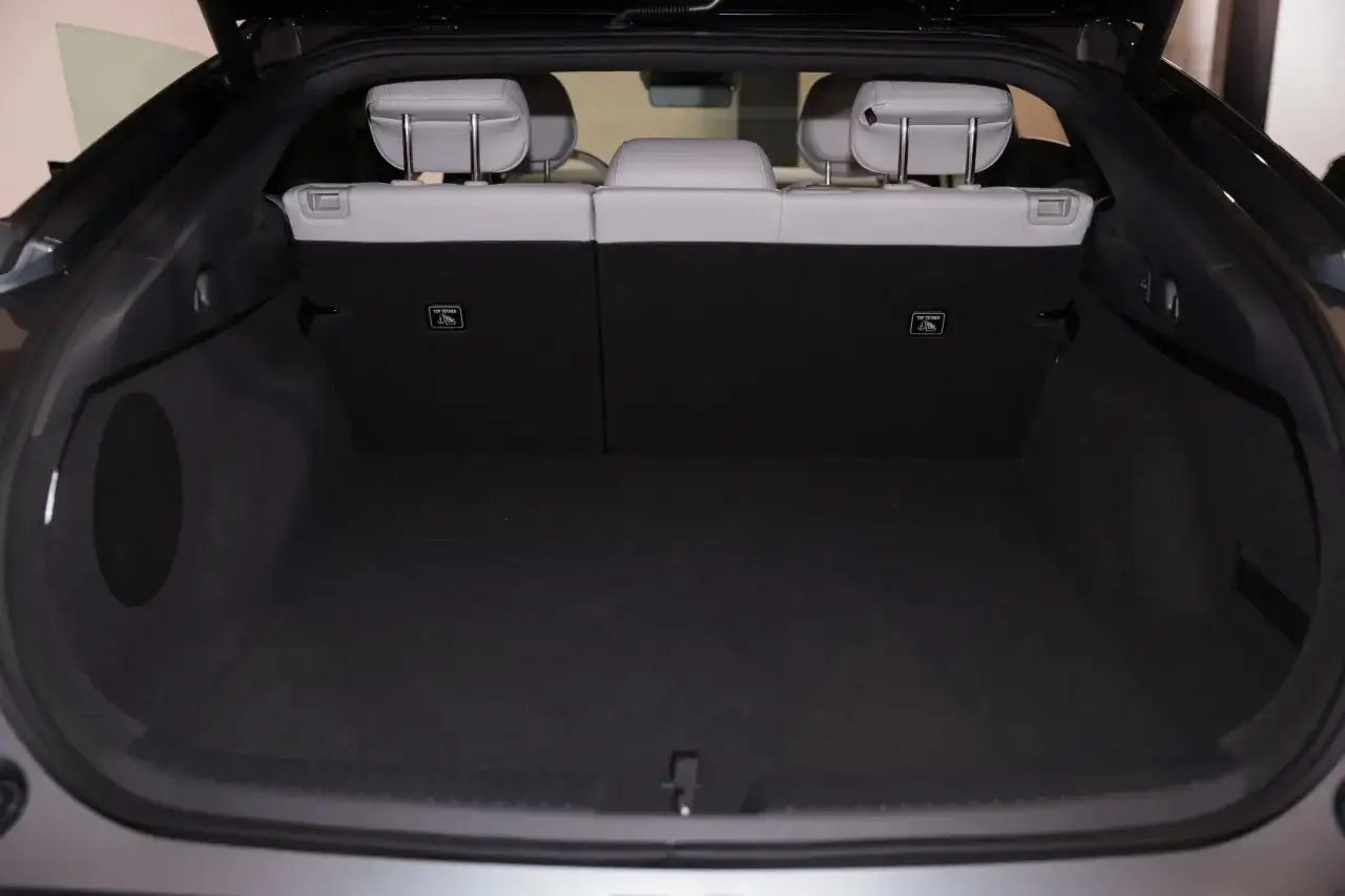 Pusty bagażnik elektrycznego Mercedesa EQB z jasnymi zagłówkami i czarnymi siedzeniami.