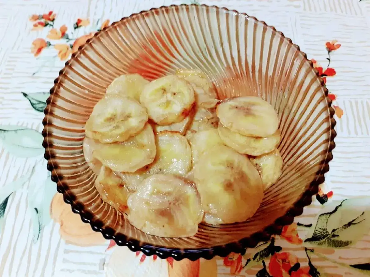 Fette di banana caramellate, cotte nella friggitrice ad aria, servite in una ciotola di vetro.