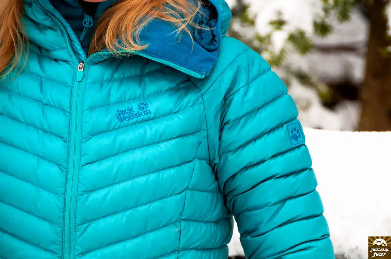 Turkusowa kurtka puchowa Jack Wolfskin, idealna na zimowe wyprawy. To właśnie kurtka parka, kt&oacute;ra chroni przed mrozem.