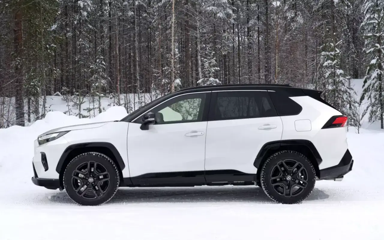 Biały SUV z czarnymi dodatkami na tle zimowego lasu. Ten model to najbardziej ekonomiczny SUV, idealny na śnieżne drogi.