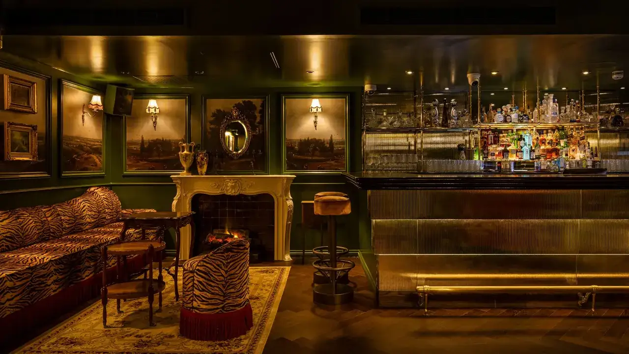 Lussuoso bar di Londra con divani zebrati, camino acceso e un'ampia selezione di liquori dietro il bancone.