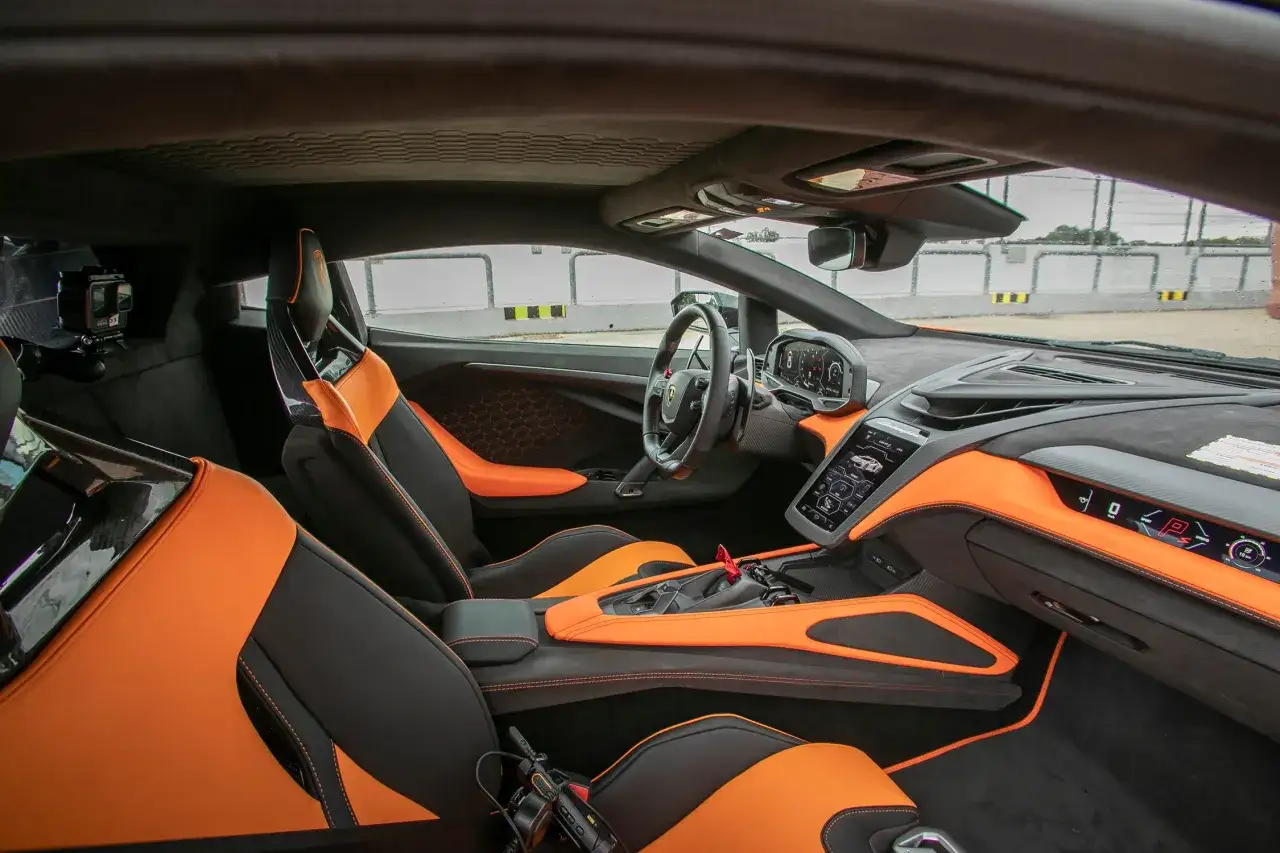Wnętrze Lamborghini Revuelto z pomarańczowo-czarną tapicerką i nowoczesnym kokpitem.