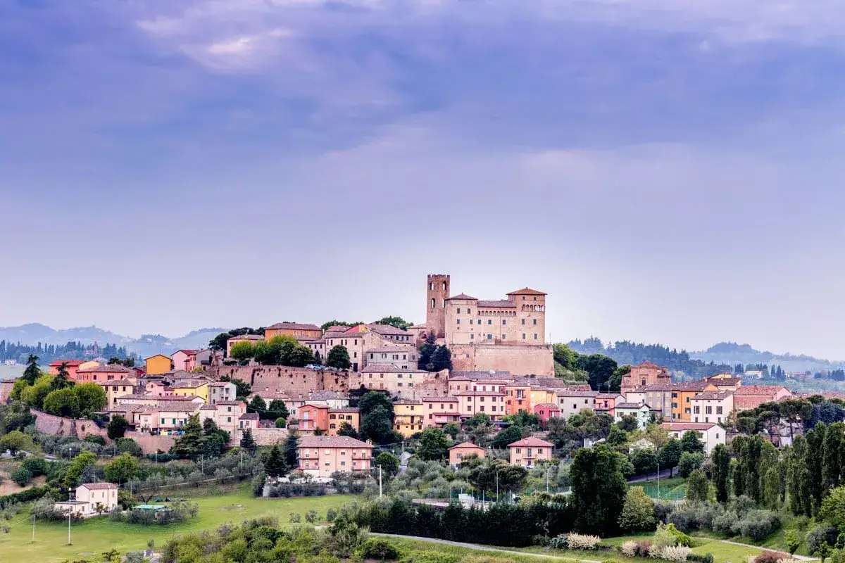 Borgo medievale arroccato sulla collina, con un imponente castello, domina la valle del Rubicone. Case colorate si aggrappano al pendio.