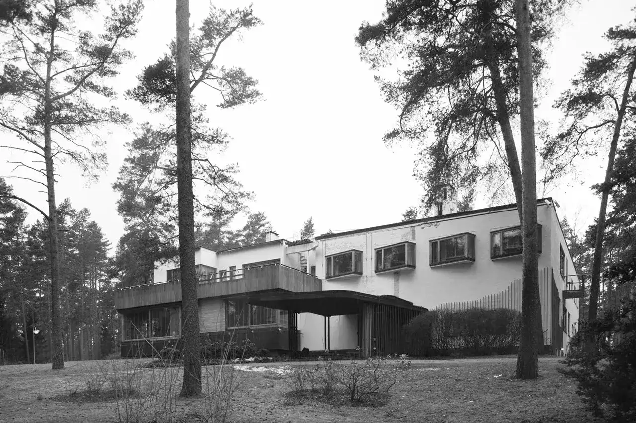 Villa Mairea, modernistyczna rezydencja otoczona sosnami, z charakterystycznymi oknami i drewnianym tarasem.