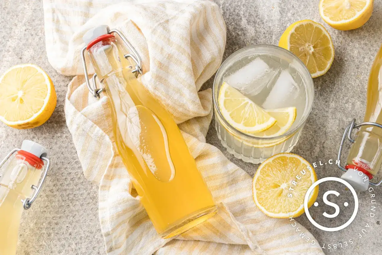 Erfrischender Zitronensirup im Glas mit Eis und Zitronenscheiben. Ein einfaches zitronensirup rezept f&uuml;r hei&szlig;e Tage.