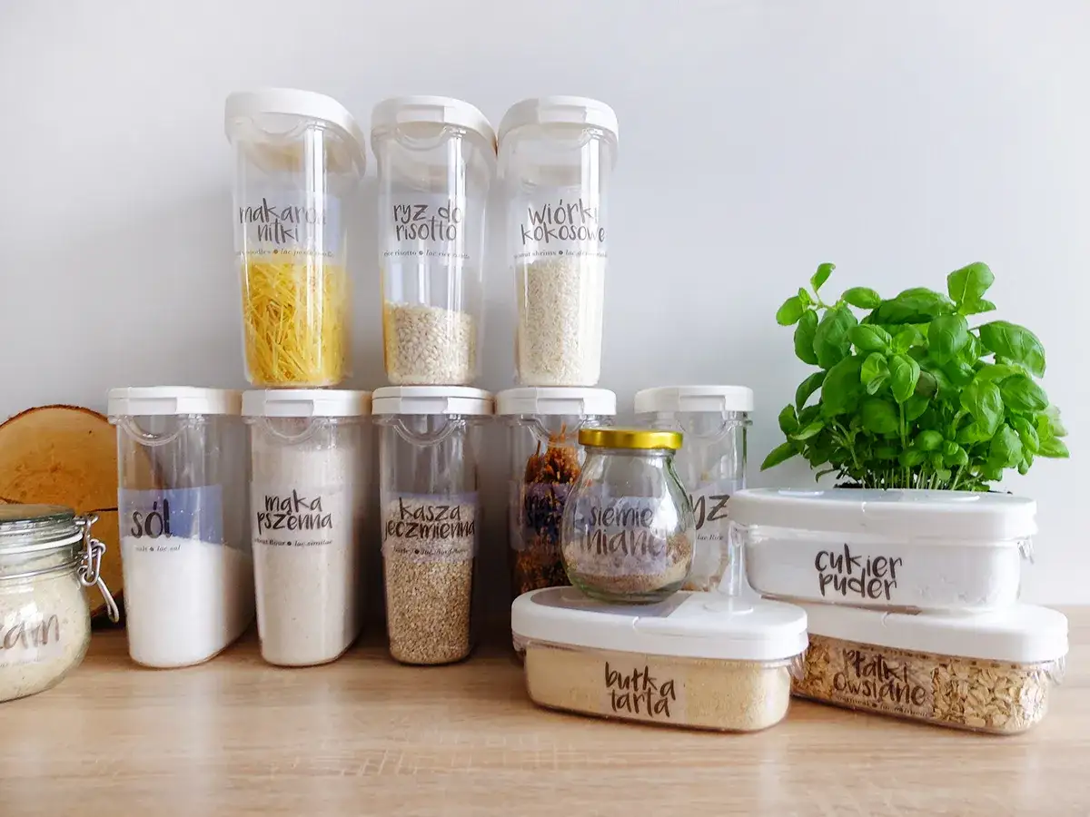 Pojemniki z makaronem, ryżem, mąką pszenną, kaszą, cukrem pudrem i płatkami owsianymi pokazują, jak przechowywać mąkę i inne sypkie produkty.