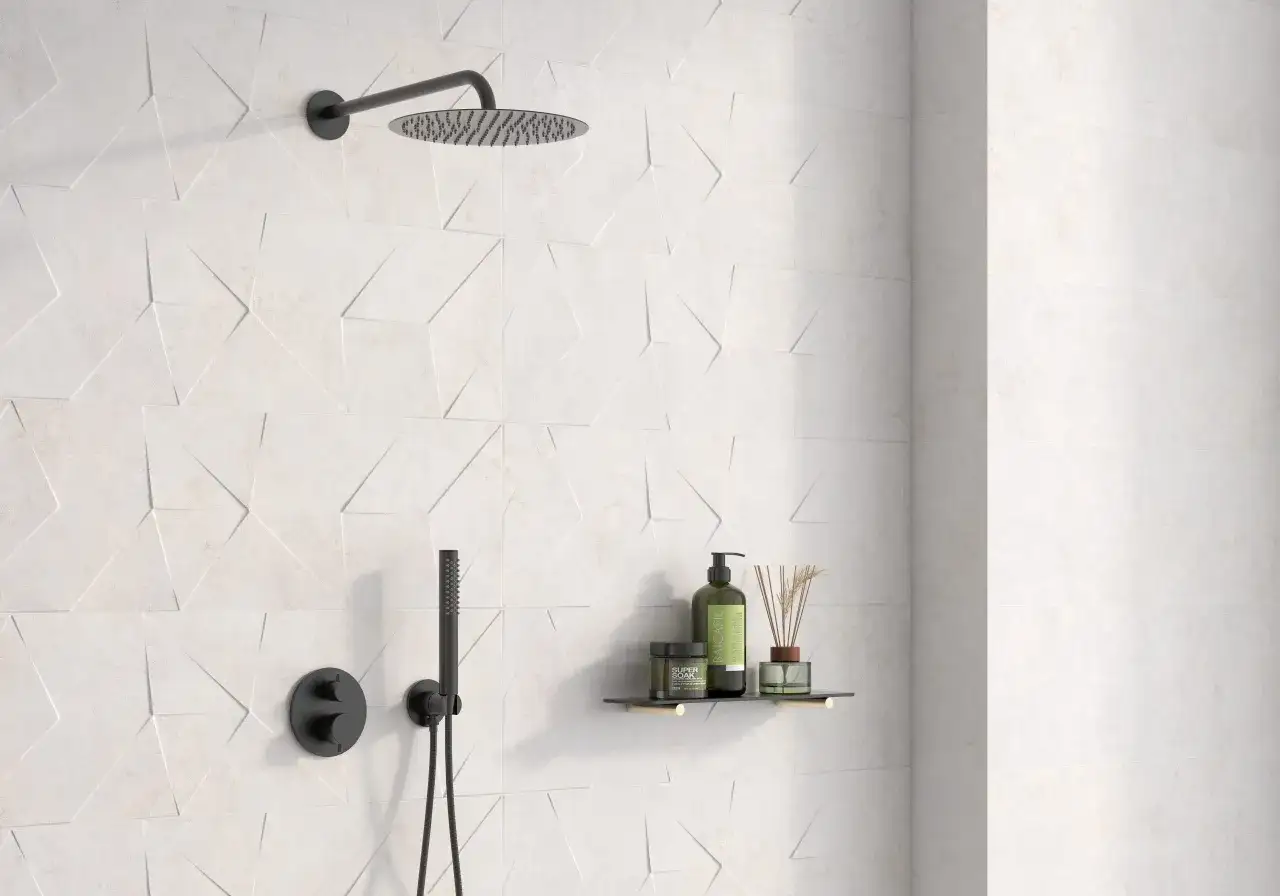 Ducha moderna con azulejo rectificado de dise&ntilde;o geom&eacute;trico en relieve. Incluye rociador, grifer&iacute;a negra y estante con productos de ba&ntilde;o.