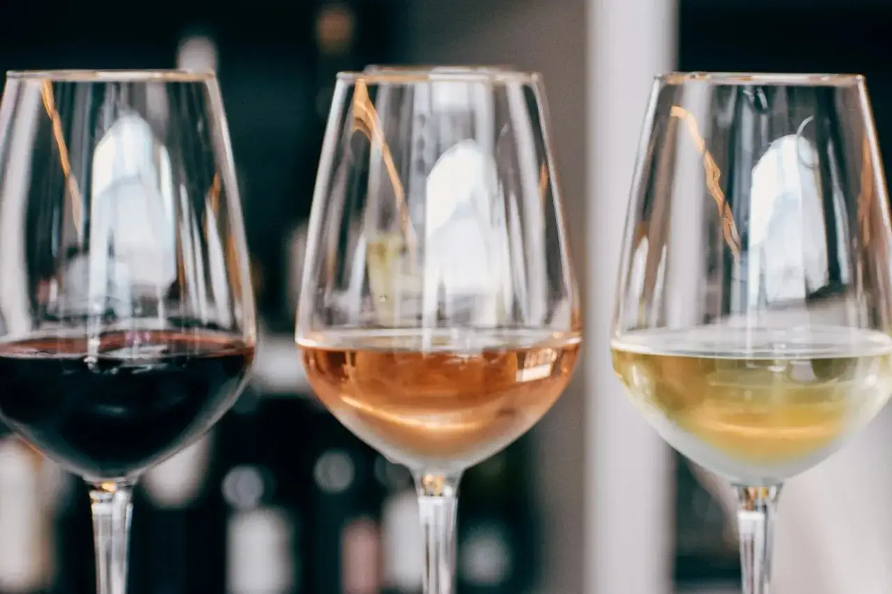 Drei Gl&auml;ser mit Rotwein, Ros&eacute; und Wei&szlig;wein. Eine Verkostung, die zeigt, welche Weinsorten es gibt.