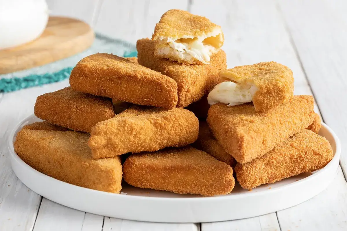 Un mucchio di formaggio in carrozza dorato e croccante, con il formaggio filante che fuoriesce da alcuni pezzi.