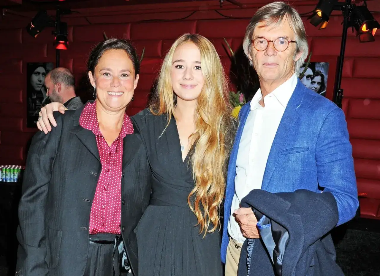 Bille Augusts barn, en kvinna och en ung flicka, poserar med en man i bl&aring; kavaj.