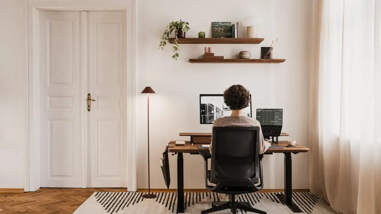 Persona lavora al PC, con la giusta posizione schermo per il comfort. L'ambiente &egrave; un ufficio domestico ordinato.