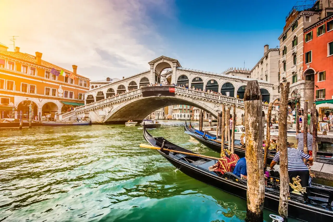 Gondole ormeggiate sul Canal Grande, con il Ponte di Rialto sullo sfondo. Un'indimenticabile gita a Venezia.