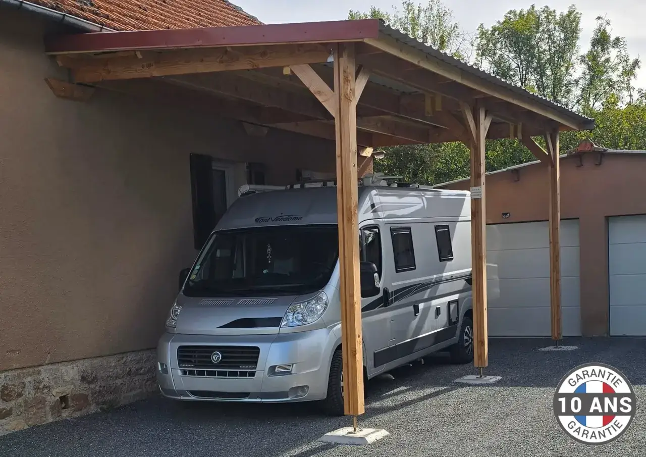 Un camping-car est garé sous un abri en bois, une solution pratique pour fabriquer un abris camping-car pas cher.