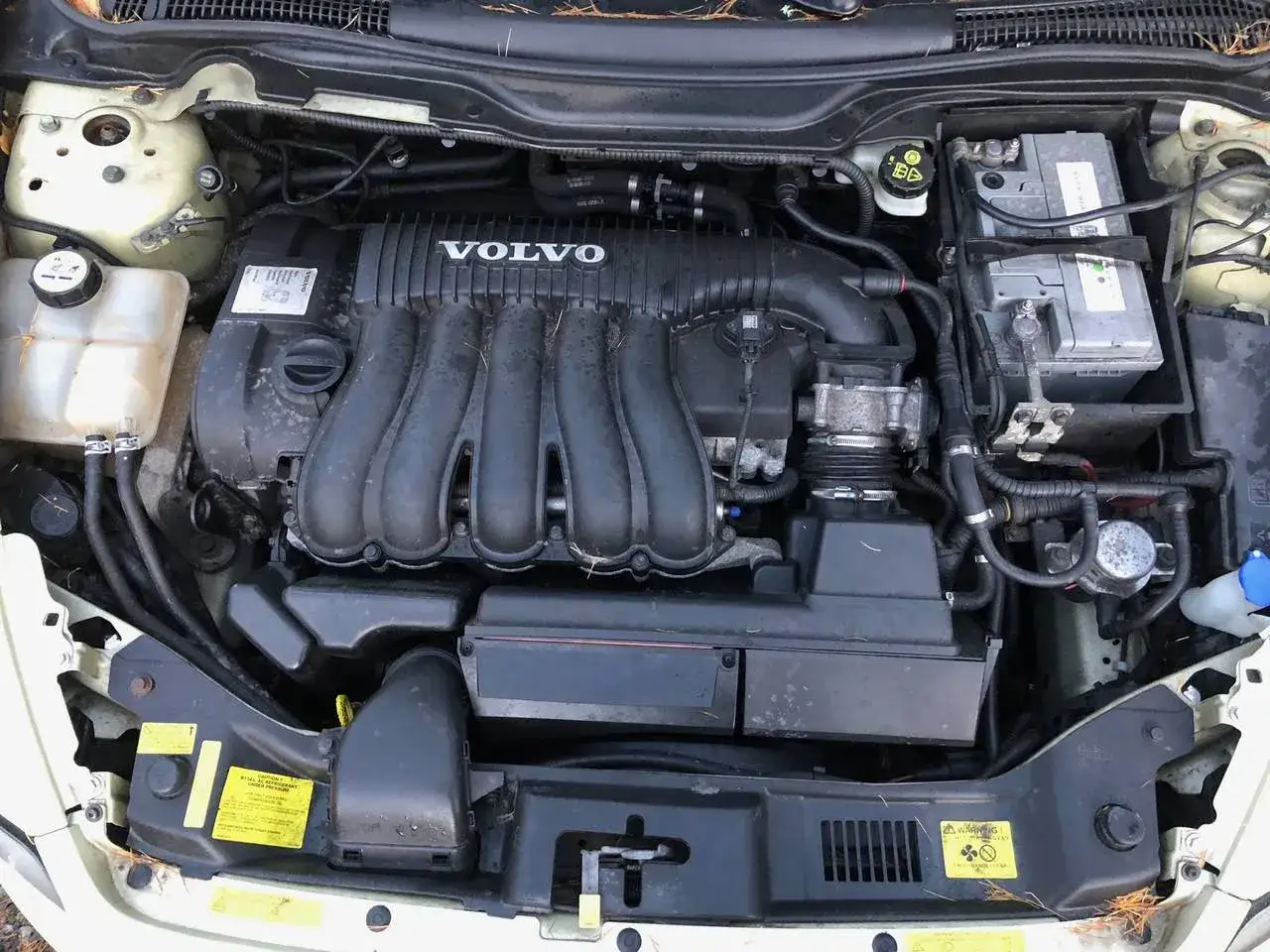 Motorutrymmet på en Volvo V50. Motorn ser lite smutsig ut, kanske är det därför volvo v50 startar inte.