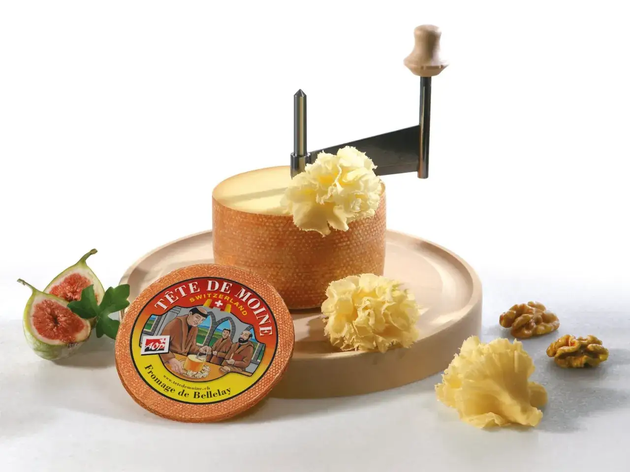Fromage Tête de Moine, un délice suisse, est présenté avec sa girolle, des figues et des noix. L'origine de ce fromage est mise en avant.