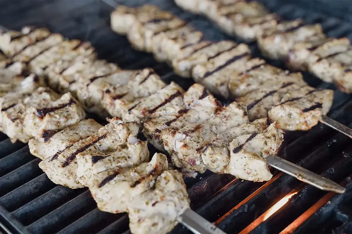 Saftige Hähnchen-Souvlaki-Spieße brutzeln auf dem Grill. Ein köstliches Souvlaki Rezept, das nach Sommer schmeckt.