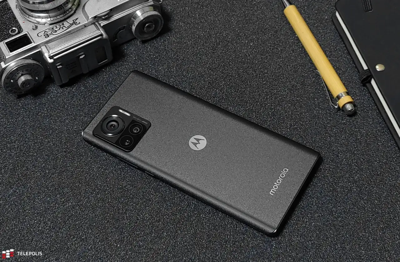 Motorola edge 30 ultra z aparatem 200MP obok starego aparatu i notatnika.