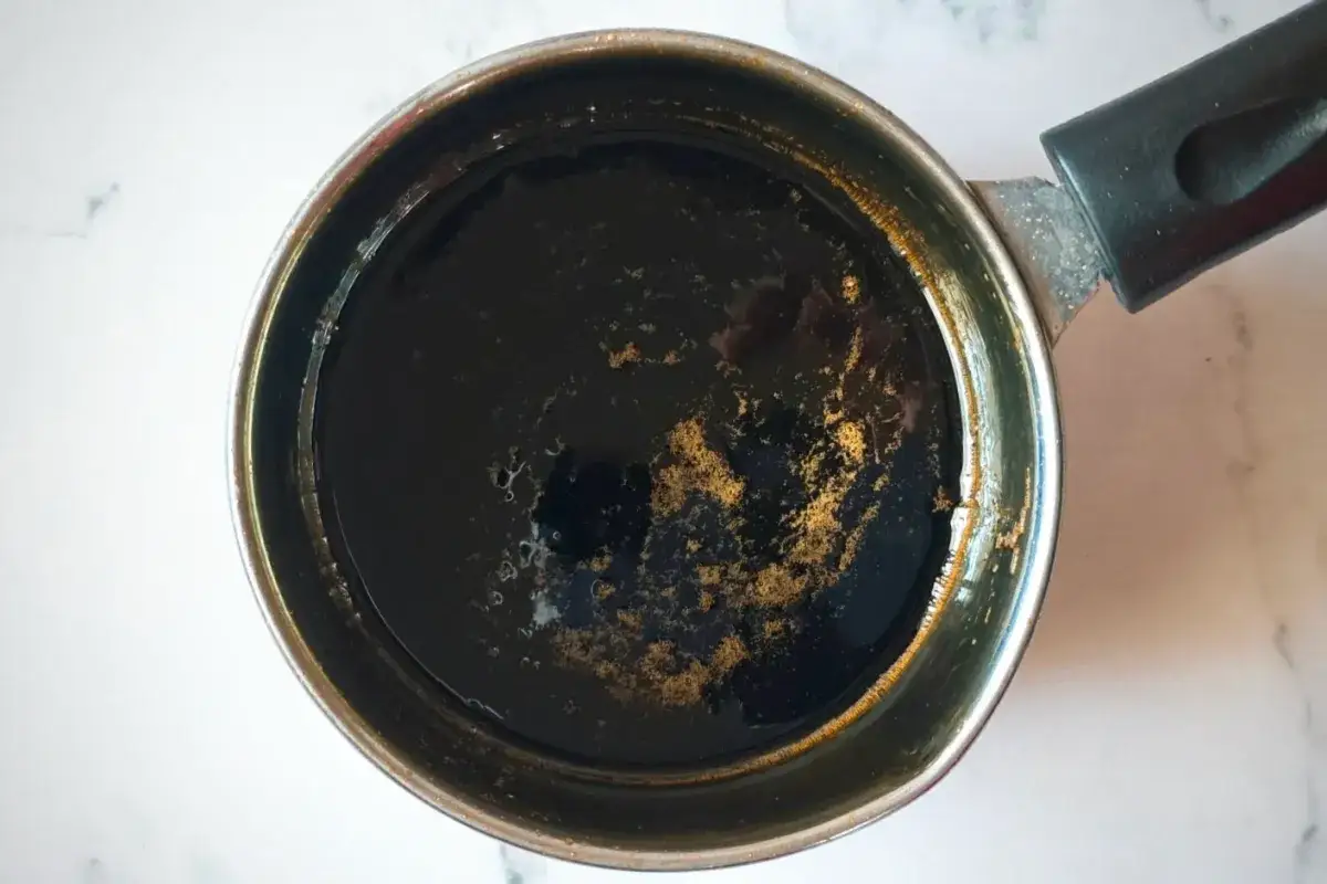 A dark, rich liquid simmers in a small pot, hinting at the delicious process of how to make unagi sauce.