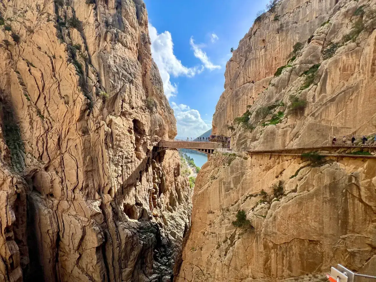 Vandrare på den dramatiska gångvägen Caminito del Rey, högt uppe bland klipporna med en flod nedanför.