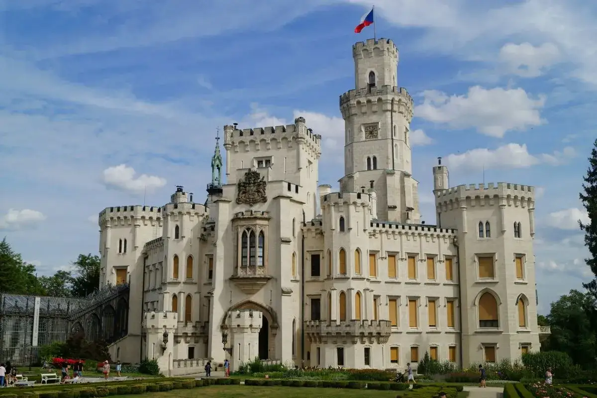 Biały zamek w Czechach, z wieżą i flagą, jak z bajki! Ciekawostki dla dzieci o tym miejscu czekają.