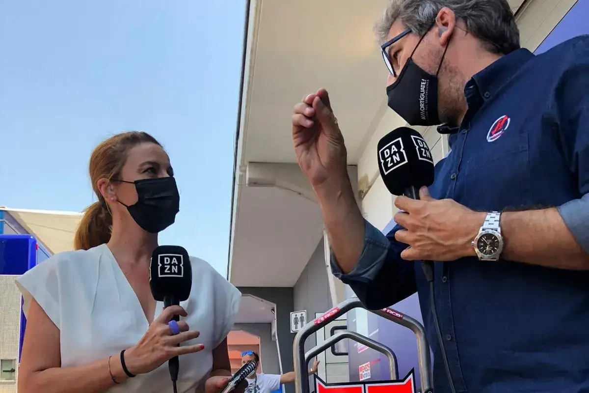 Entrevista a Juan Mart&iacute;nez en el paddock de MotoGP. Ambos llevan mascarillas y micr&oacute;fonos de DAZN.
