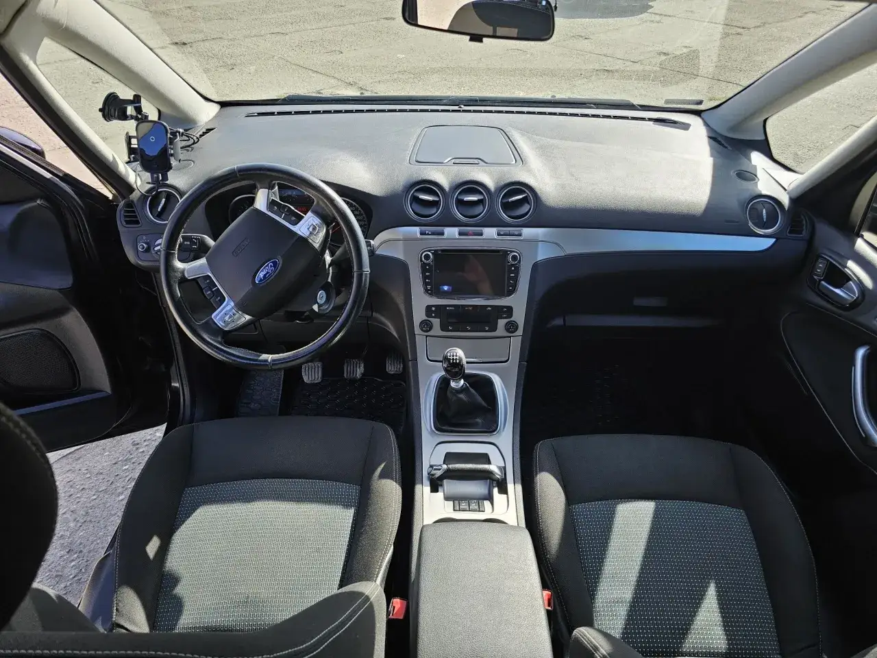 Wnętrze Ford Galaxy MK3: kierownica, deska rozdzielcza z ekranem, fotele i dźwignia zmiany biegów.