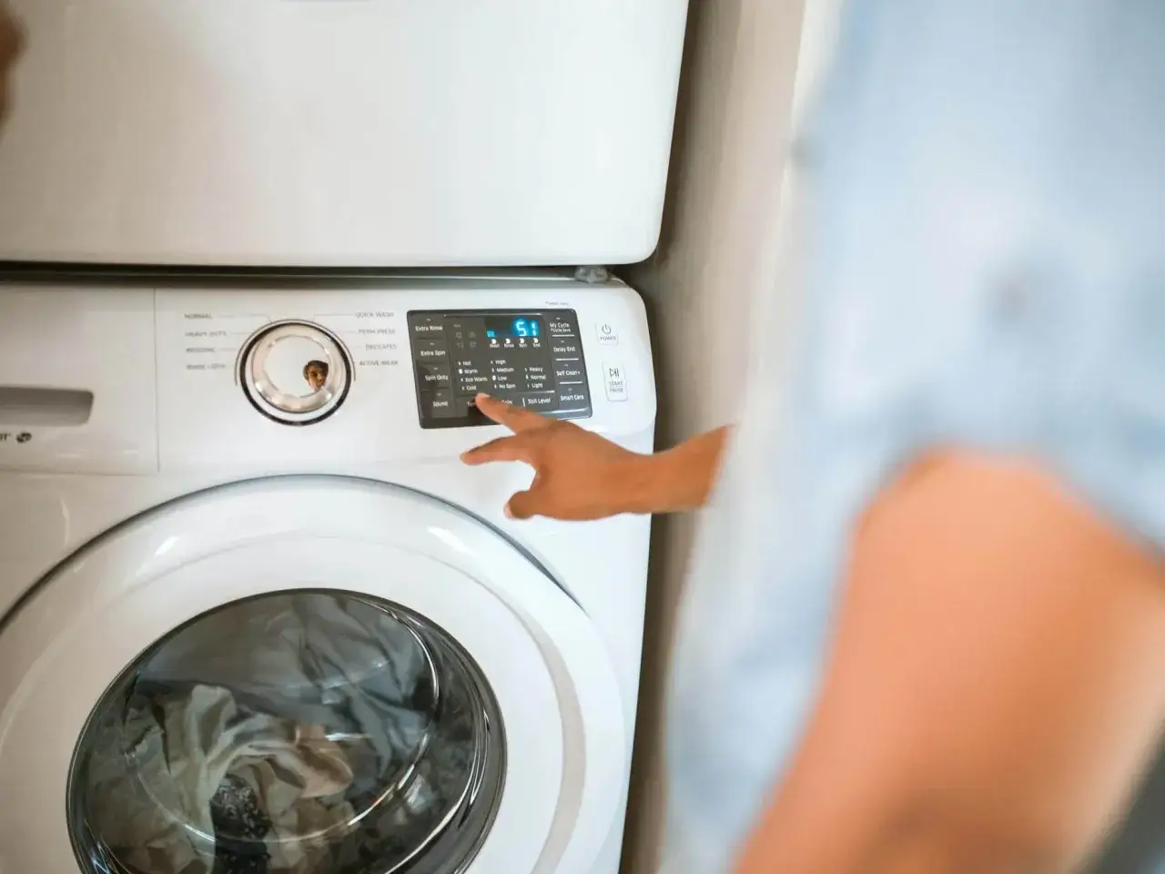 Finger w&auml;hlt das Jeans waschen Programm an der Waschmaschine aus.