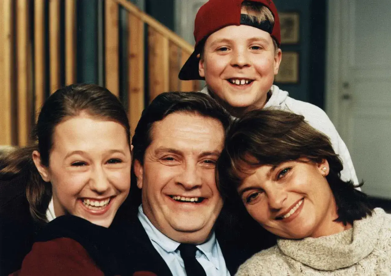 Familjen Svensson ler glatt mot kameran. Pappa, mamma, dotter och son, alla samlade f&ouml;r ett klassiskt familjeportr&auml;tt.
