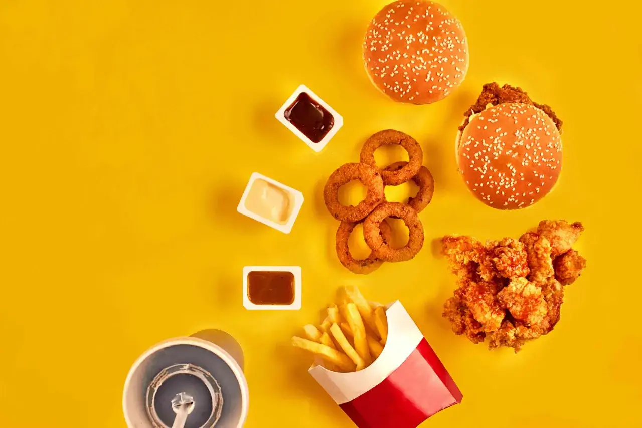 Burger, frytki, krążki cebulowe i kurczak – kusząca uczta pełna pustych kalorii.