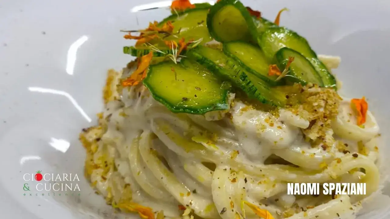Scialatielli al limone cremosi, guarniti con zucchine sottili e fiori eduli. Un piatto fresco e profumato.
