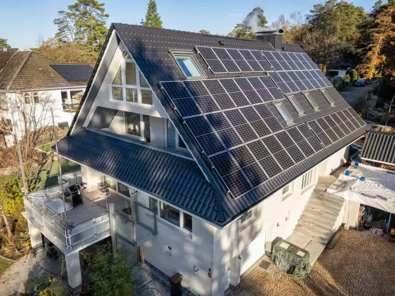 Ein modernes, energieautarkes Haus mit einer gro&szlig;en Photovoltaikanlage auf dem Dach.