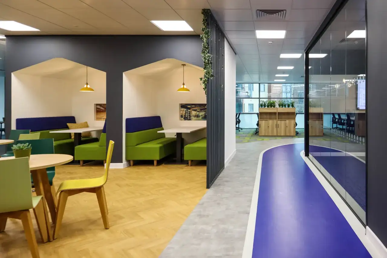 A modern office with colorful seating pods and a blue running track. This space feels like a coach of a team, ready to strategize and inspire.