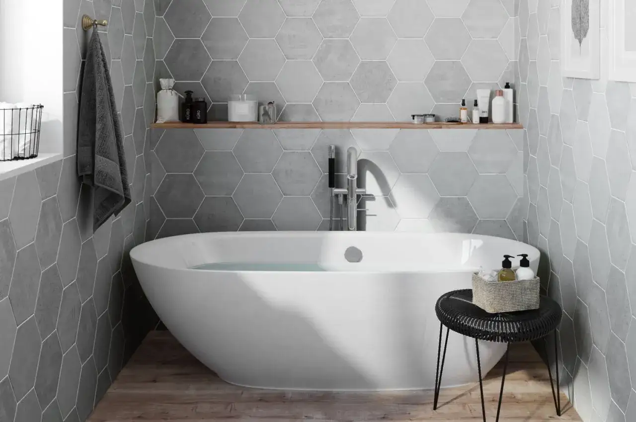 Salle de bain moderne avec baignoire &icirc;lot, mur en pose carrelage hexagonal gris et &eacute;tag&egrave;re en bois.