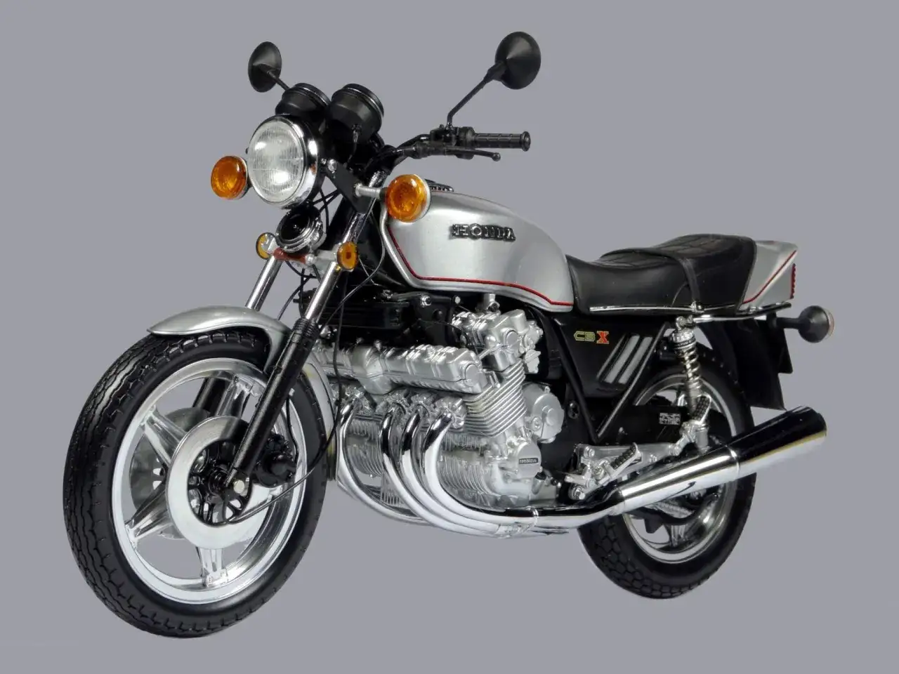 Srebrny motocykl Honda CBX 1000 z sześciocylindrowym silnikiem i chromowanymi wydechami.