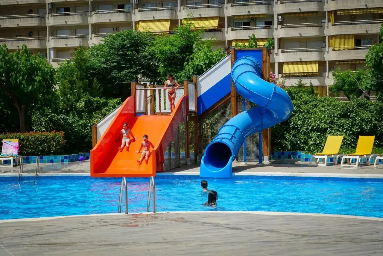 Niños disfrutan toboganes y piscina en el hotel Belvedere Salou.