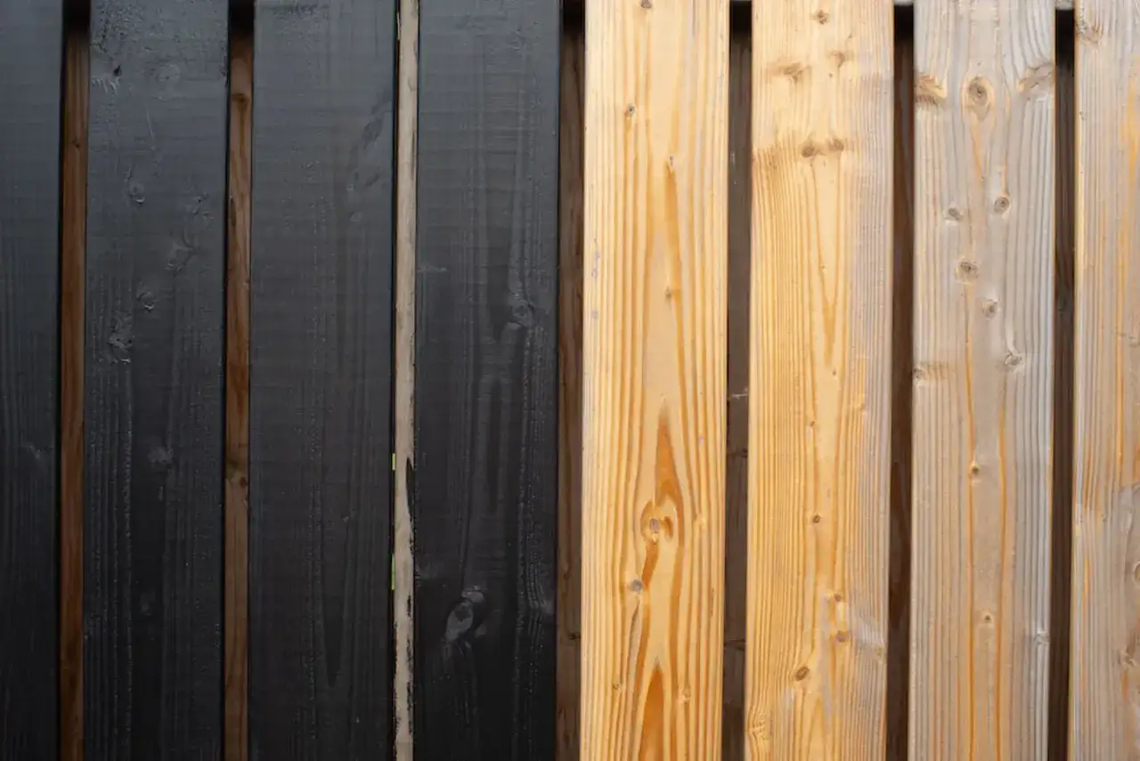 Holzlasur sch&uuml;tzt Holz. Hier eine Seite schwarz lasiert, daneben unbehandeltes Holz.
