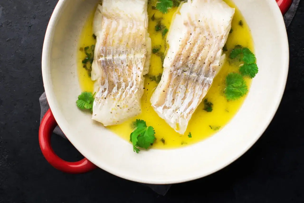 Dwa filety halibuta w maślanym sosie z ziołami. Zdrowe danie, idealne dla dbających o halibut kcal.