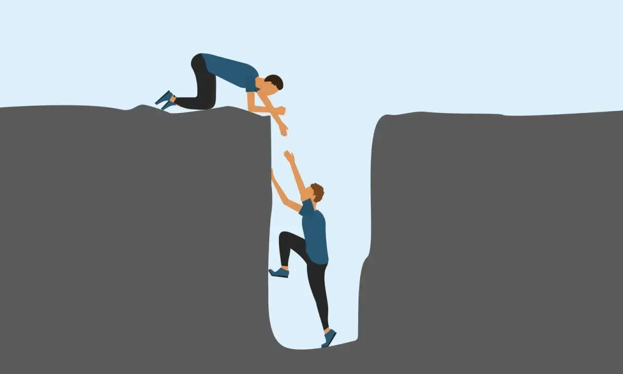 Ein Mann hilft einem anderen aus einer tiefen Schlucht. Ein Beispiel f&uuml;r das Helfersyndrom, bei dem man sich selbst gef&auml;hrdet, um anderen zu helfen.