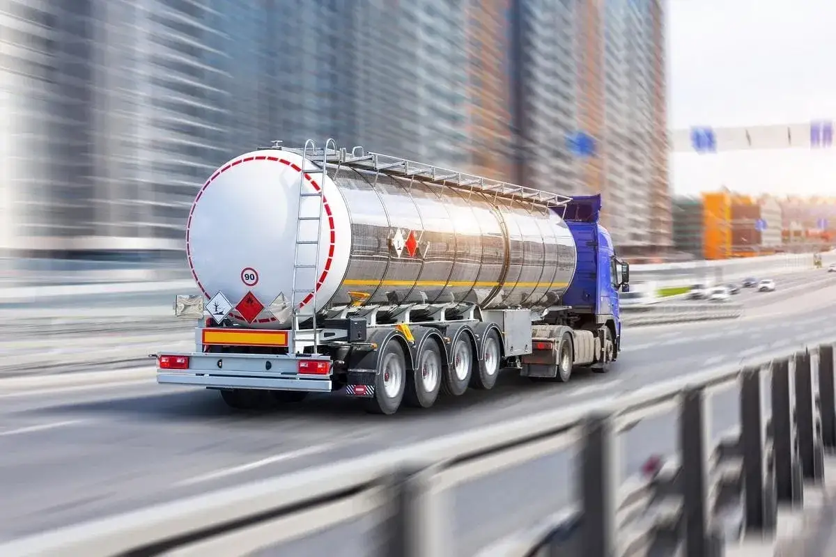 Ciężarówka z cysterną przewożąca niebezpieczne materiały, posiadająca odpowiednie **uprawnienia ADR**, pędzi autostradą.