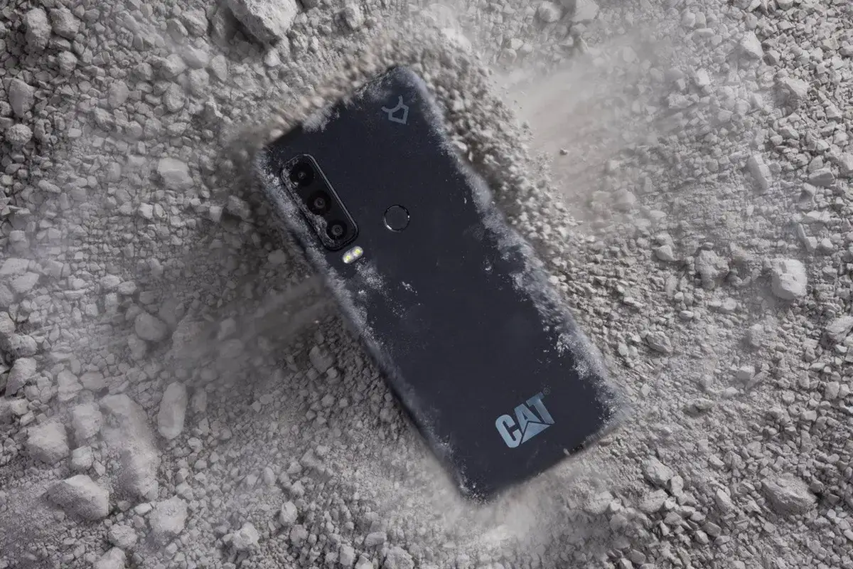 Telefon CAT najnowszy, odporny na upadki, leży na kamieniach.