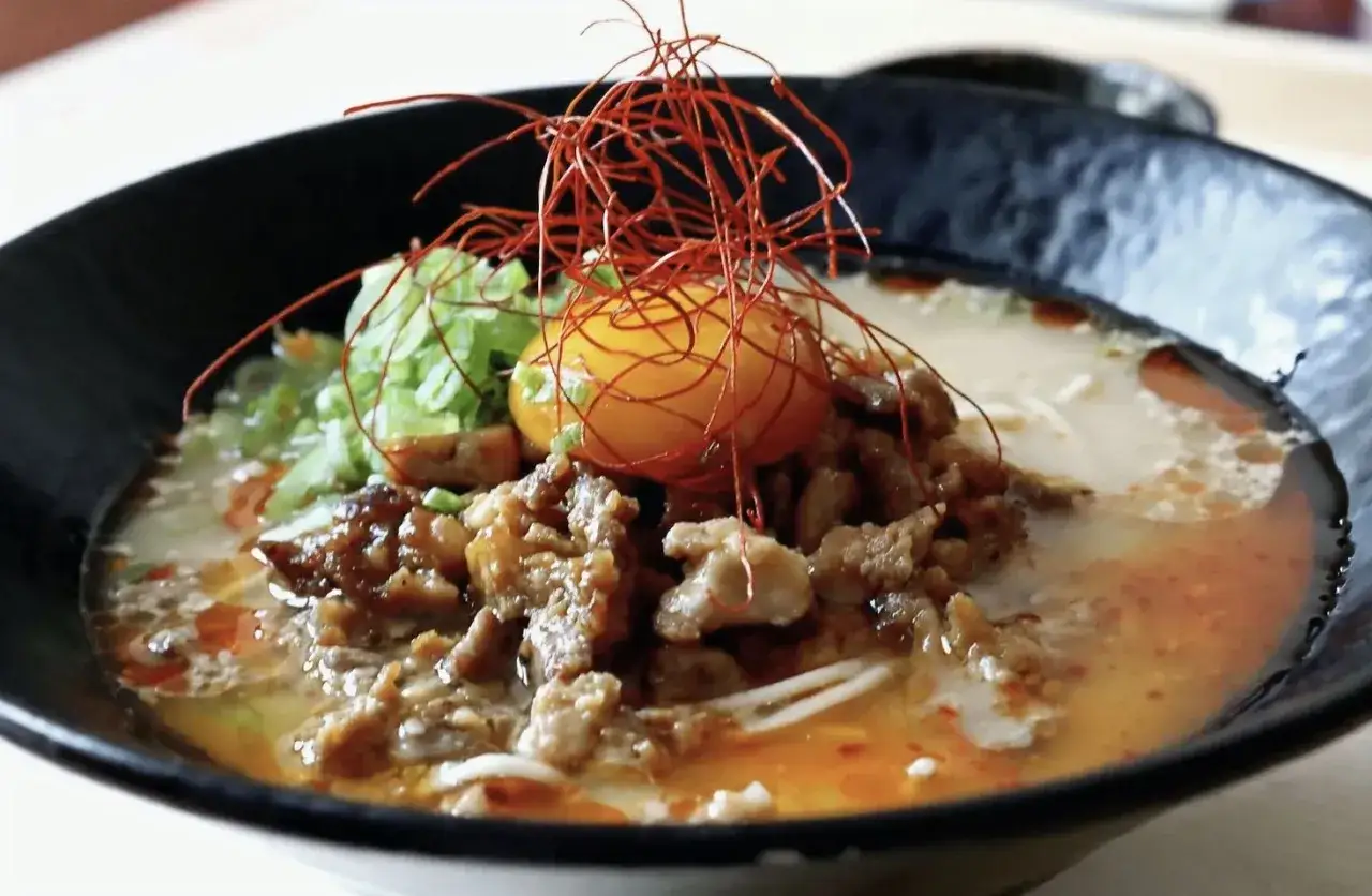 Aksamitny bulion, makaron i kawałki mięsa tworzą apetyczny ramen z kaczki, zwieńczony żółtkiem i nitkami chili.