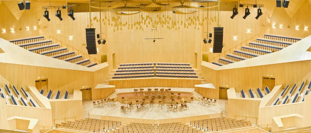 Interior de una sala de conciertos moderna, con asientos de madera y azul, lista para un evento en la casa grande Zaragoza.