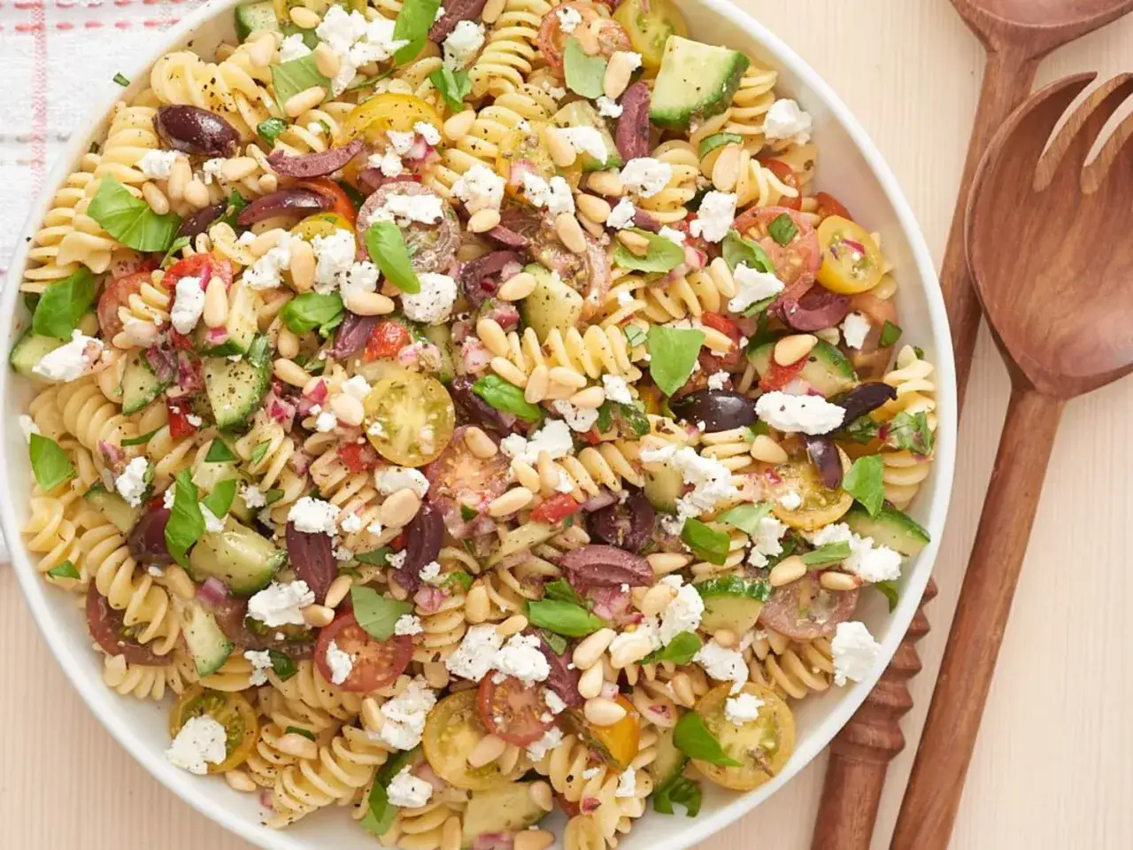 Ein bunter Nudelsalat ohne Mayo mit Fusilli, Tomaten, Gurken, Oliven, Feta und Pinienkernen. Perfekt für den Sommer!