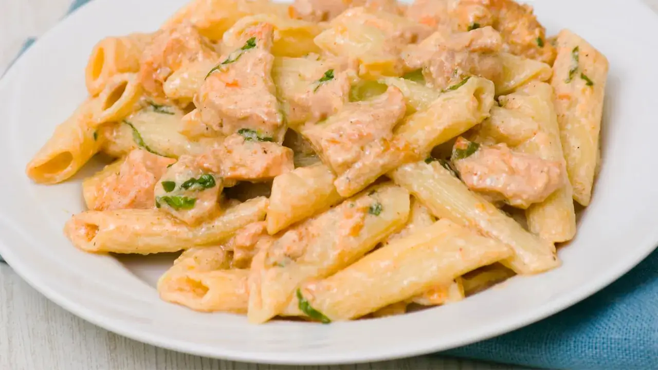 Penne z tuńczykiem w kremowym sosie śmietanowo-serowym, posypane zieloną pietruszką. Pyszne danie, które zachwyci każdego miłośnika makaronu.