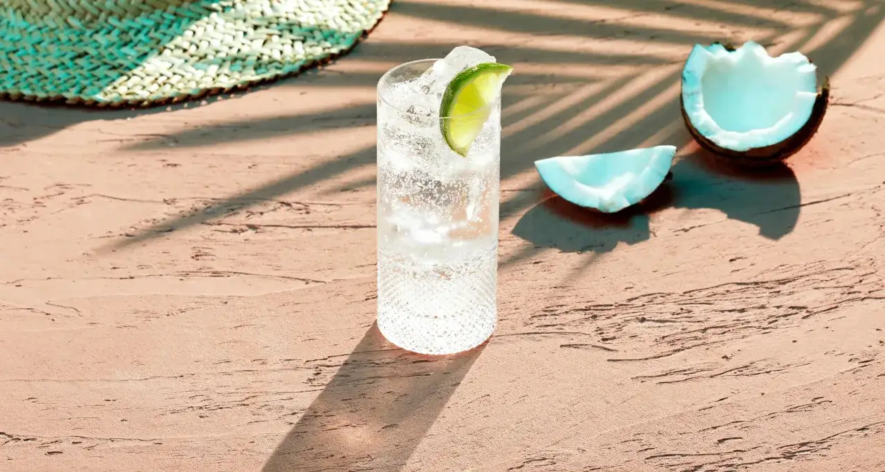 Orzeźwiający drink z Bacardi kokosowym, lodem i limonką na plaży. Idealny na upalne dni.
