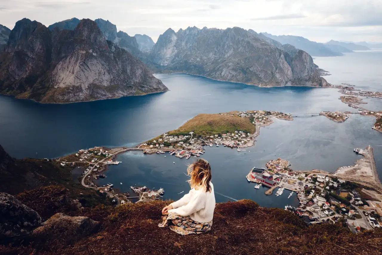 Mujer contempla las Islas Lofoten. Descubre cómo llegar a este paraíso noruego.