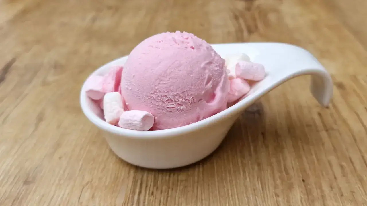 Ein Löffel rosa Kaugummi-Eis mit Marshmallows in einer weißen Schale. Perfekt für ein schnelles Kaugummi Eis Rezept.